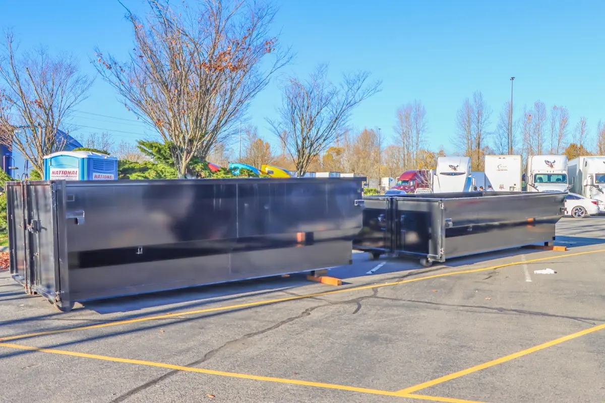 Professional dumpster rental service with roll-off container on residential driveway in Tupelo